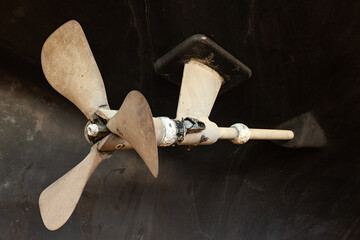 Folding propeller blades mounted at the stern of a sailing yacht.
