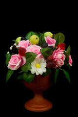 Exclusive handmade soap in the form roses peonies daisies berries and fruits in a vase on a black background.