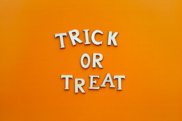 Obraz premium Words trick or treat. Wooden letters with lettering on top of orange background. Happy halloween
