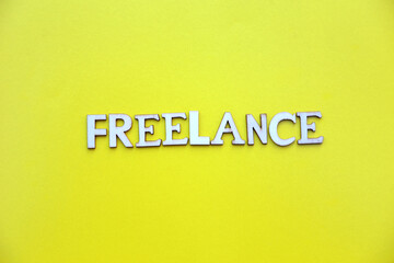 Word freelance. Wooden letters with lettering on top of yellow background. Human Resource Management and Recruitment and Hiring concept.