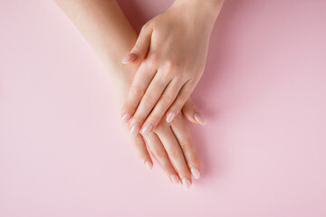 Obraz na płótnie Canvas Beautiful female hands on pink background. Spa and body care concept. Image for advertising.