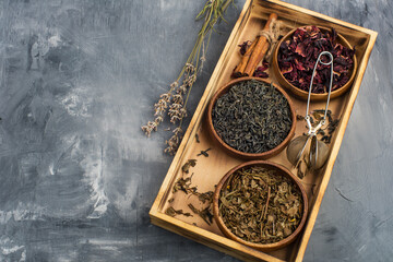 assortment of dry tea in wooden bowls and teapot