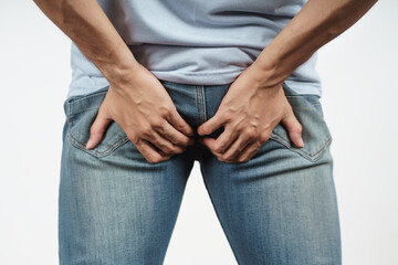 Young Man holding his bottom because Diarrhea, Hemorrhoids, constipation. Health care and medical...