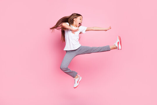Full size profile photo of nice optimistic blond girl fight wear white t-shirt isolated on pastel pink color background