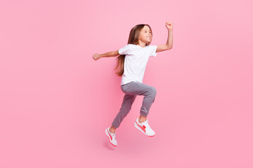 Full length body size view of attractive cheerful girl jumping running isolated over pink pastel color background
