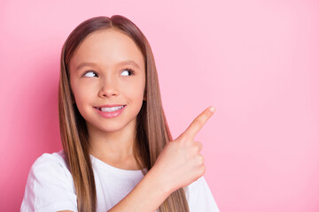 Photo of nice optimistic blond girl point empty space wear white t-shirt isolated on pastel pink...