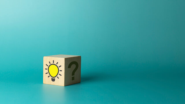 Wooden cube with bright light bulb and question mark on green background. Concept of Idea, solution and creative - Powered by Adobe