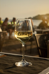 sunset dinner next to the sea with white wine glass