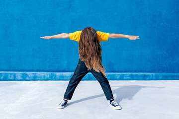 Unrecognizable teenager dancing on blue background