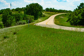 Fototapeta na wymiar Paved two lane road leading away from congestion and into the peaceful countryside of rural America such as this scene in North Dakota.