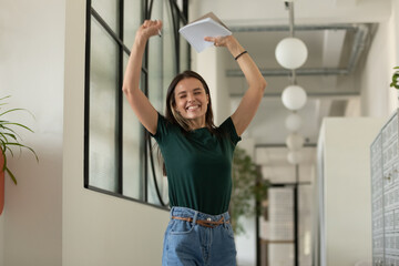 Happy excited student celebrating success, passed exam, high test grade, good result. Millennial...