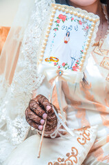 A Moroccan bride with a henna tattoo on her hands holding a sign that says I am the bride