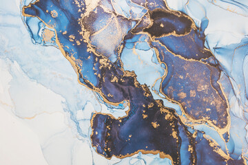 Luxury abstract fluid art painting in alcohol ink technique, mixture of dark blue, gray and gold paints. Imitation of marble stone cut, glowing golden veins. Tender and dreamy design.