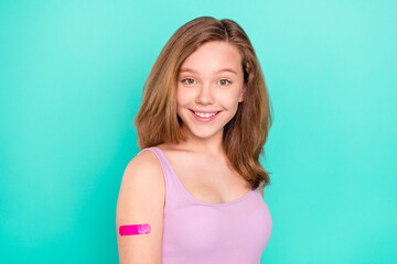 Photo of optimistic brown little girl show plaster wear violet top isolated on teal color background