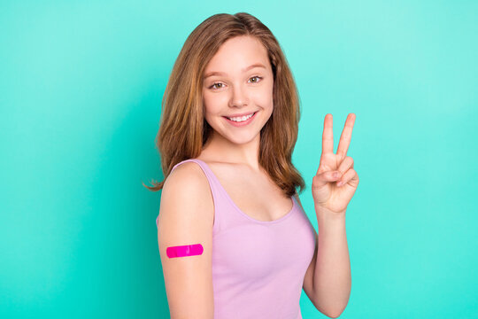 Photo portrait girl smiling did vaccination showing v-sign isolated vivid teal color background