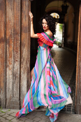 Fototapeta premium Beautiful woman in the flowers dress in summer city