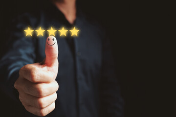 Customer satisfaction concept. Hand with thumb up Positive emotion smiley face icon and five star with copy space on black background