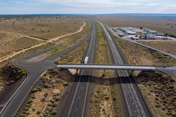Aerial horizontal panorama view of truck stop on the highway car parking lot endless Interstate highway in desert Arizona