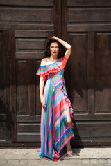 Fototapeta premium Beautiful woman in the flowers dress in summer city