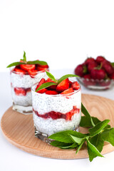 Summer tasty natural dessert with fresh strawberry, yogurt and chia seeds on the table. Diet breakfast. Сlose-up.