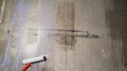 Man painting cement walls using roller brush and primer making a renovation. Priming the old wall...