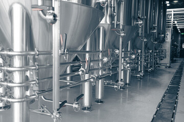 Private microbrewery. Modern beer plant with brewering kettles, tubes and tanks made of stainless steel