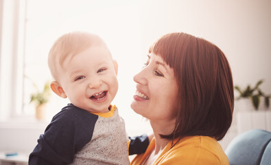 Happy mother holding in her arms her smiling son.