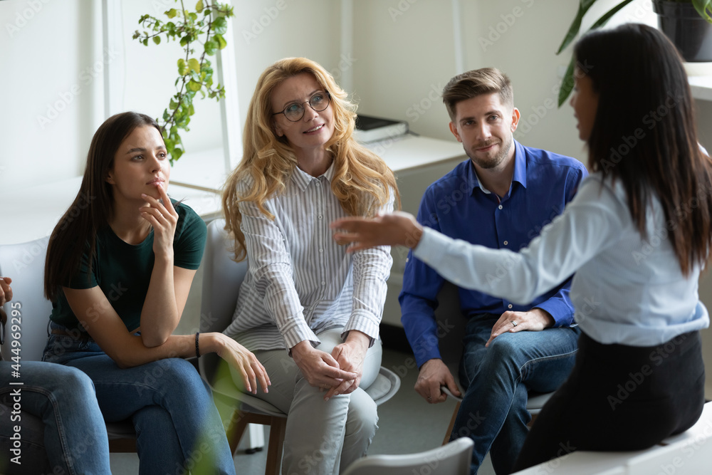 Wall mural Business team of different aged employees listening to speaking female leader, presenter, discussing project ideas, solutions, meeting and talking in office. Mixed raced mentor, teacher training staff