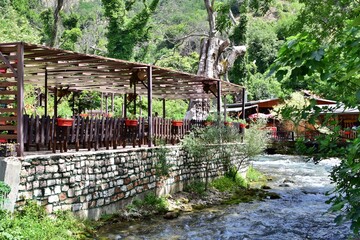 Fototapeta na wymiar Open terrace of cozy restaurant near mountain river