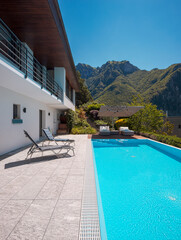Modern two-story house with large pool overlooking the mountains.