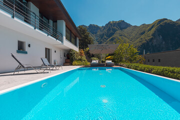 Modern two-story house with large pool overlooking the mountains.
