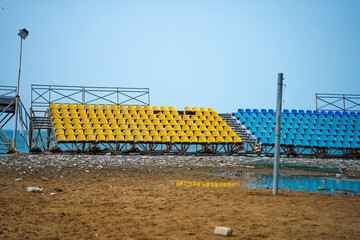 Deserted stands of a small sports field on the beach on a rainy day