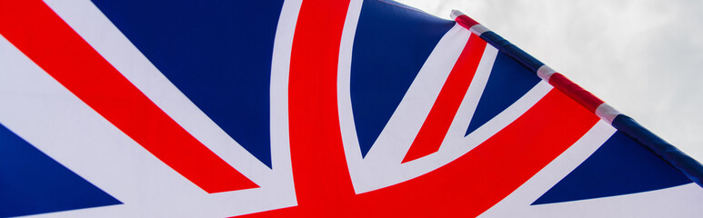 close up view of national flag of united kingdom with red cross against sky, banner