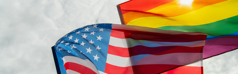 low angle view of american and lgbt flags against sky, banner