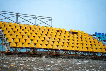 Yellow plastic seats on the podium of a small sports field