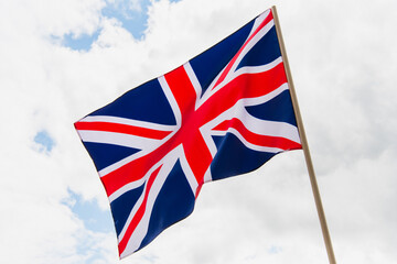 national flag of united kingdom with red cross against sky