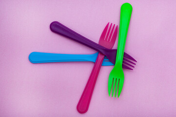 colorful plastic forks on color background with copy space