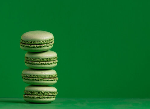 Composition with french macarons on green background.