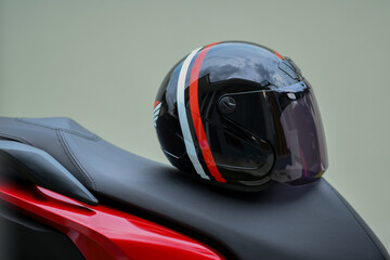 A black helmet is placed on the seat of a motorbike.