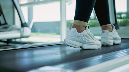 woman running at fitness gym on machine treadmill.