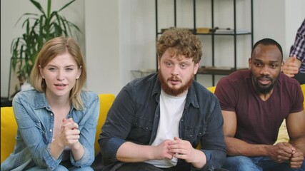 A multinational group of men and women looking into the camera with excitement and worrying, then rejoice and celebrate their victory. Slow motion.