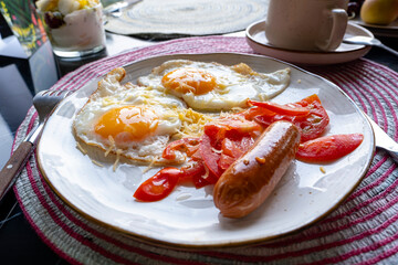 Scrambled eggs with tomatoes, sausage and cheese. Delicious, hearty and healthy breakfast