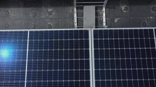 Up close view of solar panels as the sun reflects on them moving over each section.