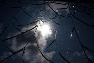 Broken glass over sky and sun behind the cloud background.