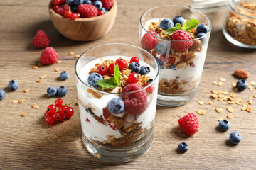 Tasty dessert with yogurt, berries and granola on wooden table