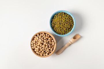 dry chickpeas, green mung bean, in a ceramic dish on a white table