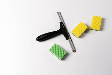 cleaning tools, scraper, window nozzle and colored washcloths on a white background