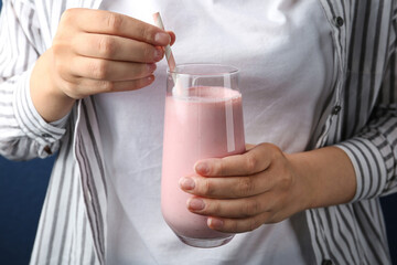 Woman with glass of tasty smoothie, closeup