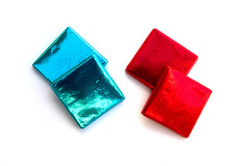 four small chocolates in a blue and red wrapper on a white background