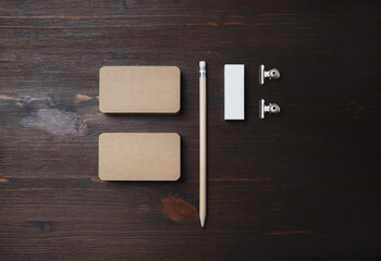 Blank kraft business cards, pencil and eraser on wood table background. Stationery mock up....